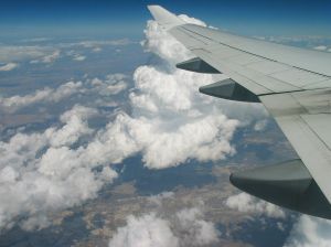 It is partly cloudy outside the airplane window during the flight.